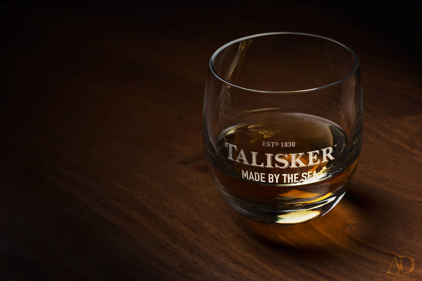 Bottle of Talisker whisky photographed in warm low light with reflective highlights.